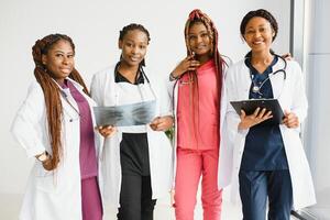 grupo do africano americano médico e enfermeira dentro hospital ala. foto