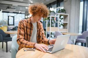 animado muito feliz jovem o negócio homem aluna vencedora olhando às computador portátil comemoro aposta licitação ganhar conectados sucesso vitória Novo oportunidade sentar às cafeteria mesa, ler Boa Internet o email notícias, obteve Novo trabalho oferta foto