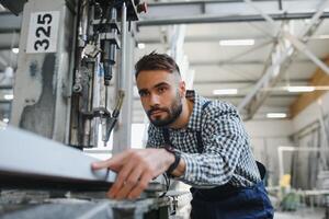 feliz profissional pesado indústria engenheiro trabalhador vestindo uniforme, e Difícil chapéu dentro uma aço fábrica. sorridente industrial especialista em pé dentro uma metal construção fabricação foto