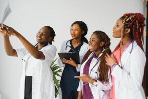grupo do africano americano médico e enfermeira dentro hospital ala. foto