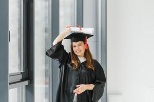 graduação aluna em pé com diploma foto