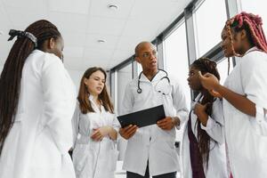 grupo do africano americano médico e enfermeira dentro hospital ala. foto