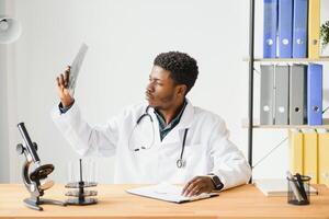 africano americano médico olhando às pacientes raio X dentro escritório. foto