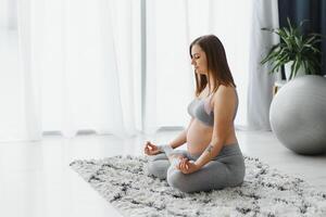 gravidez, ioga, pessoas e saudável estilo de vida conceito - feliz grávida mulher meditando às casa, vintage estilo foto