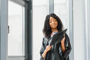 lindo africano fêmea aluna com graduação certificado foto