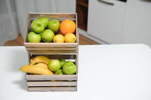 feito à mão kraft caixa com frutas e legumes em cozinha fundo. foto