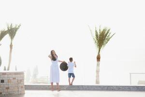 feliz família mãe e filho em a de praia de a mar dentro verão foto