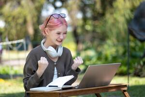 mulher trabalhando às a computador portátil dentro a quintal com uma muitos do vegetação, computador portátil e retrato do mulher dentro parque para Educação foto