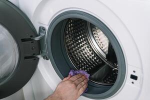 masculino mão limpar \ limpo a lavando máquina. detalhe limpeza conceito do lavando máquina. inoxidável tambor dentro, fechar-se foto