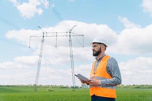 engenheiro trabalhando perto transmissão linhas. elétrico engenheiro Verificações Alto Voltagem linhas. transmissão torres foto