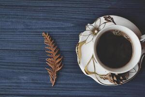 uma copo do café em a de madeira escrivaninha. Sombrio azul madeira. vintage. estilo de vida. manhã humor. foto
