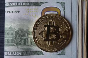 dourado bitcoin e dólares dentro masculino mão em uma Sombrio azul de madeira fundo. ouro moeda do criptomoeda. foto