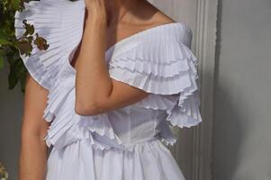 garota, mulher noiva vestido dentro uma branco vestir em uma cinzento fundo. elegante Casamento vestir com à moda inchado mangas e decote. foto