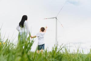 alternativo energia, vento Fazenda e feliz Tempo com seu família. feliz mãe em a estrada com dele filho em período de férias e fuga para natureza. foto