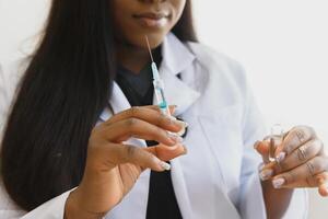 Preto africano fêmea médico usando teste injeção antes usando isto. foto
