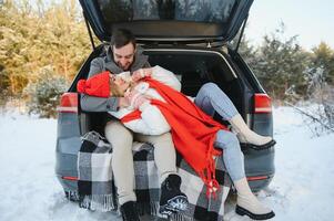 feliz casal sentado dentro aberto carro voltar, tendo Pare desligado. romântico viajando conceito. inverno floresta. foto