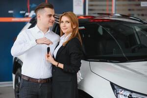 jovem lindo feliz casal comprando uma carro. marido comprando carro para dele esposa dentro uma salão. carro compras conceito foto