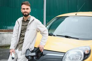 homem segurando poder conector para elétrico carro foto