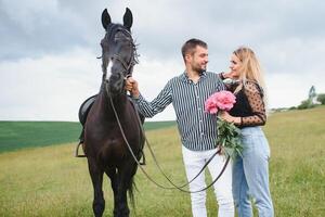 casal dentro amor tendo Diversão dentro natureza. jovem casal com uma cavalo. foto