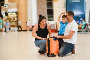 retrato do viajando família com malas dentro aeroporto foto