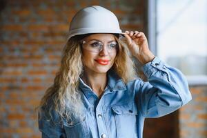 armazém mulher trabalhador. mulher construtor dentro capacete. menina engenheiro ou arquiteto. casa renovação. qualidade inspetor. construção trabalho ocupação. construção trabalhador. senhora às construção local. foto