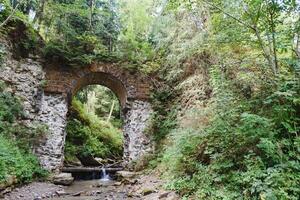 a velho estrada de ferro ponte é construído do pedra. histórico construção usava foto