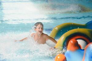 Garoto tendo Diversão dentro aqua parque foto