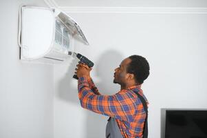 jovem africano masculino técnico reparação ar condicionador foto