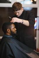 Preto homem dentro a barbearia. fofa Preto homem faz uma corte de cabelo dentro a africano salão. cabelo estilo. corte de cabelo para adultos. foto