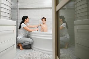 mãe e filho tendo Diversão às banho Tempo juntos foto