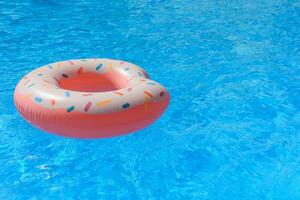 Rosa inflável rosquinha natação anel dentro uma natação piscina foto