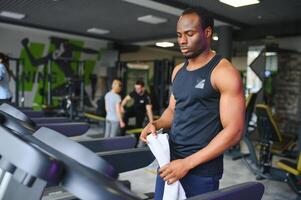 esportivo Preto homem exercício em esteira dentro ginástica clube foto