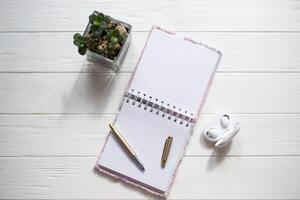 caderno e caneta em a branco de madeira mesa. foto