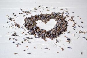 coração símbolo a partir de a lavanda flores em a branco de madeira mesa. lavanda sabor. foto