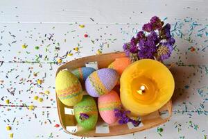 colorida Páscoa ovos com flores e amarelo vela dentro a cesta. lindo Páscoa fundo. Páscoa cartão. caseiro feriado decoração. foto