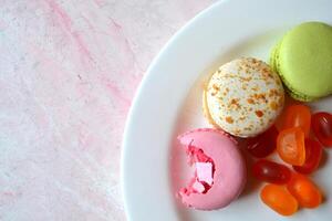 colorida Macarrão em a Rosa texturizado mesa. saboroso fundo. doce lindo bolos. foto