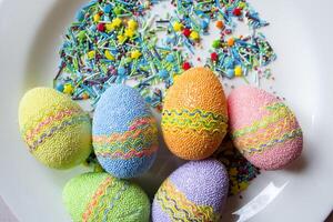 Páscoa ovos e colorida açúcar em uma branco placa. foto