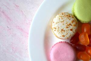 colorida Macarrão em a Rosa texturizado mesa. saboroso fundo. doce lindo bolos. foto