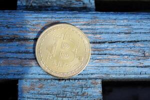 dourado bitcoin em uma azul de madeira fundo. uma moeda do criptomoeda. foto