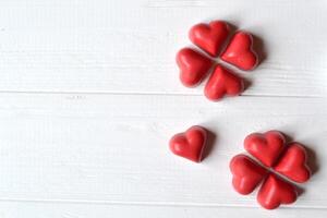 vermelho doces em a branco de madeira mesa. fundo para cumprimento cartão em dia dos namorados dia com Lugar, colocar para texto. foto