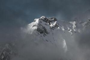 Nevado montanha dentro a nuvens foto