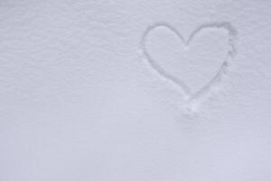 desenhado coração dentro fresco branco neve durante caminhada dentro a floresta e inverno certo foto