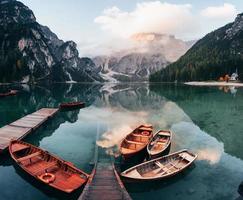 este lugar é o paraíso para os viajantes. barcos de madeira no lago de cristal com majestosa montanha atrás. reflexo na água foto
