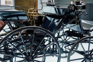 estugarda, alemanha - 16 de outubro de 2018 museu mercedes. vagão de cavalo preto. o veículo antigo parece um novo. pessoa atrás foto
