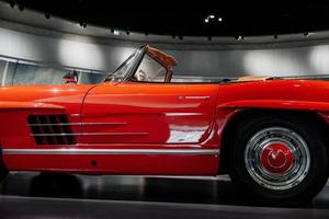 iluminação incrível e roda traseira. carro polido vermelho vintage em pé interior. foto do lado