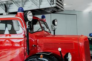 vista lateral. frente do caminhão de bombeiros polido vermelho parado em uma exposição foto