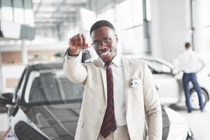 o jovem empresário negro e atraente compra um carro novo, sonhos tornam-se realidade foto