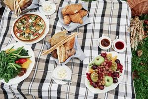 vista de cima da comida à mesa. vegetais, croissants, molhos e outros alimentos vegetarianos foto