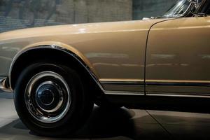 pneu esquerdo. foto de carro marrom vintage polido e brilhante estacionado dentro de casa