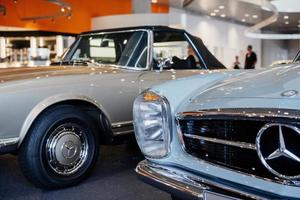 estugarda, alemanha - 16 de outubro de 2018 museu mercedes. pessoas atrás olham para os veículos. carros retrô antigos bonitos no salão do automóvel foto